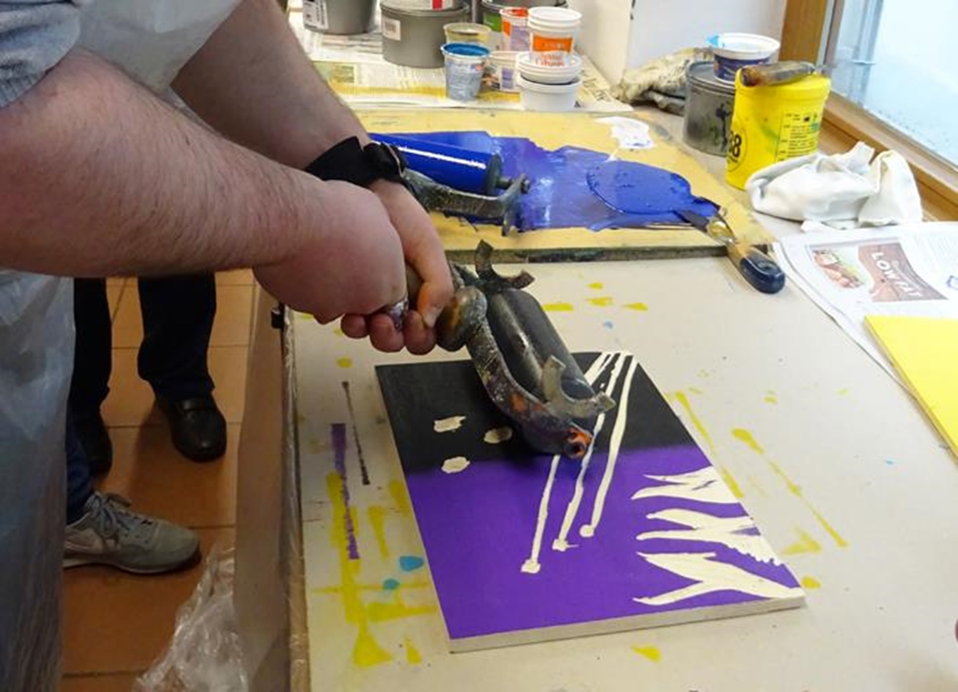 Ein Mitarbeiter der WfbM Pocking malt ein Bild